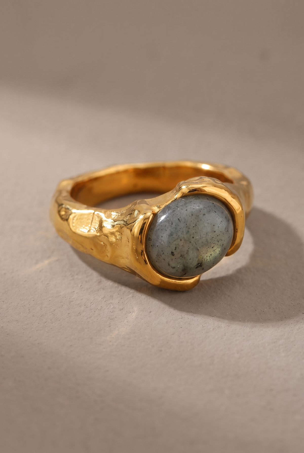 Close-up of the grey stone cabochon and hammered gold band